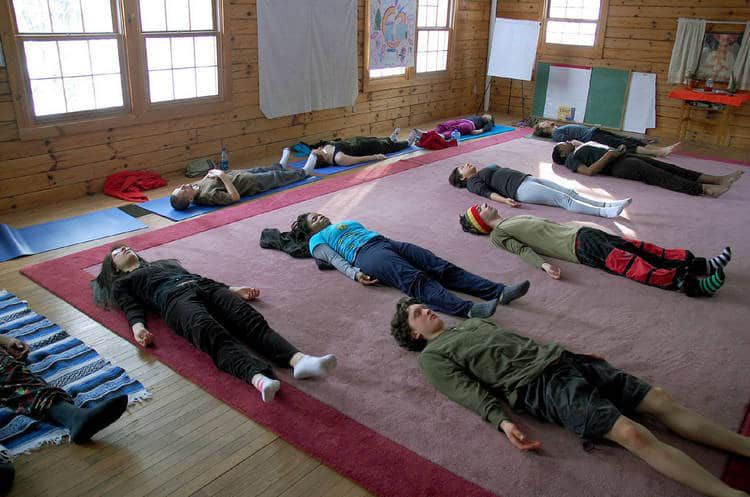 People relaxing in savasana during Yoga class - Psychological & spiritual therapy