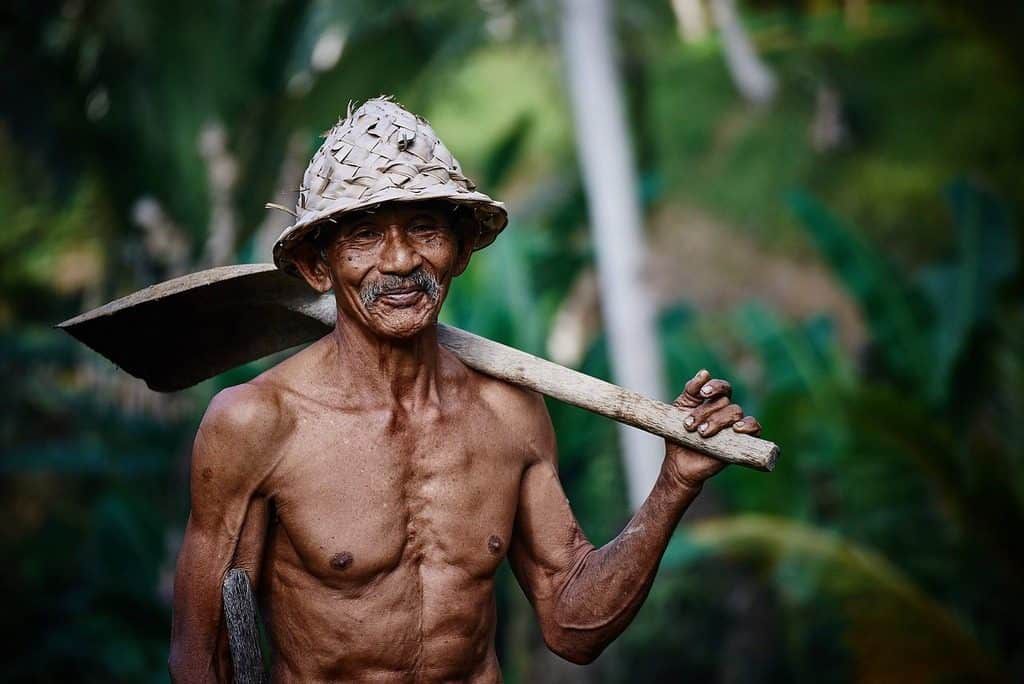 man in the jungle with shovel on shoulderr
