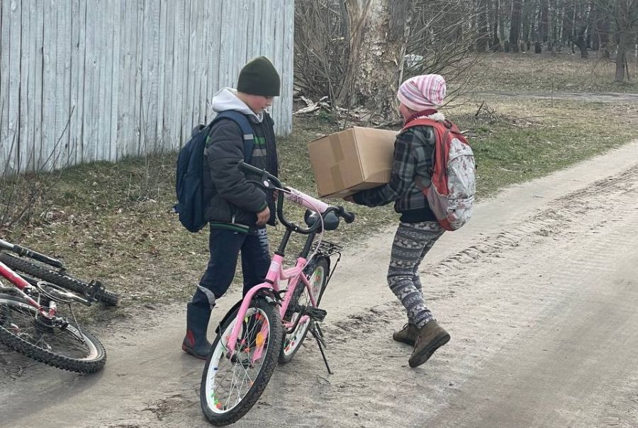 Kinder in der Ukraine nehmen die Caritas-Pakete entgegen