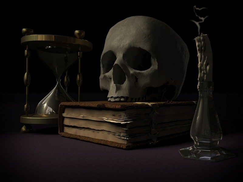 collage of a skull on top of a book with an hourglass and a snuffed out candle