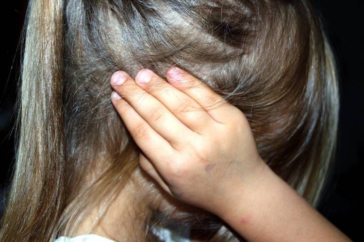Upset child putting hands over her ears - Confronting reality