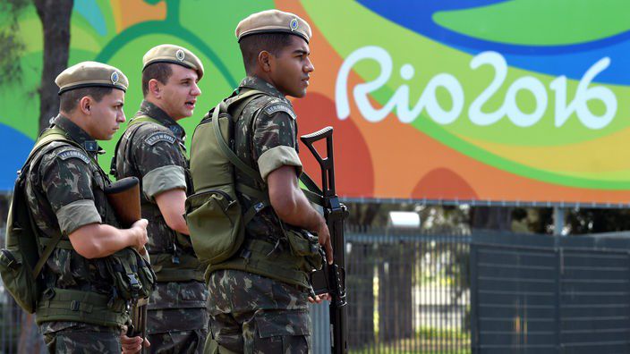 Bewaffnete Militrpolizisten im Hintergrund das Rio-Logo