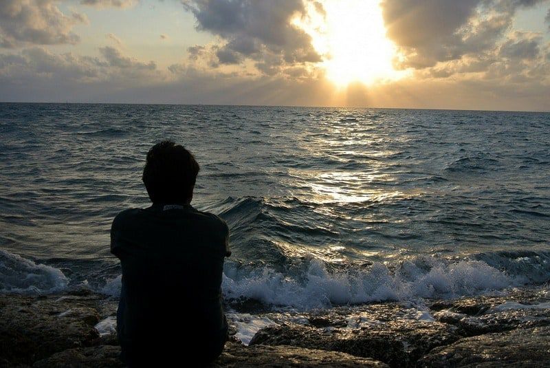Man sitting staring at the sea
