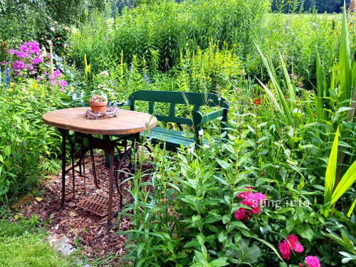 Garten im Sommer: Gartenbank mit Tisch - alte Nähmaschine