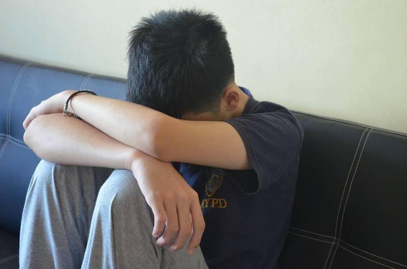 Sad teenage boy on couch - Questioning rape culture