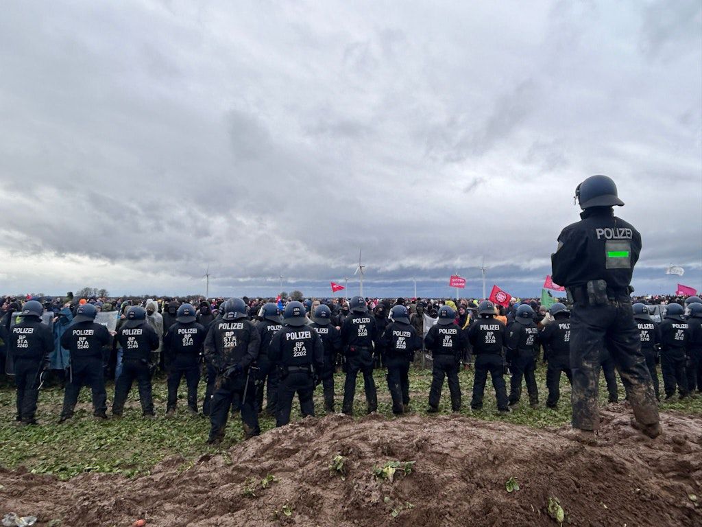Polizei und Protestierende stehen einander in Lützerath im Schlamm gegenüber