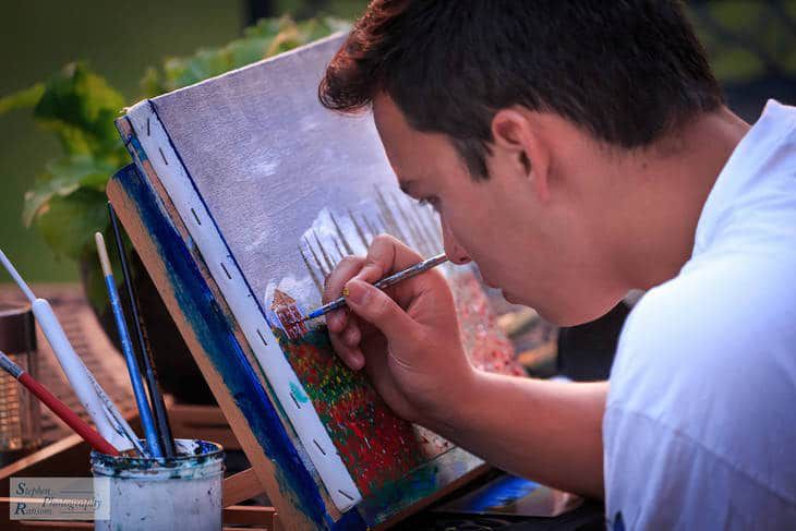 Young man painting - The Artist's Way turns 25