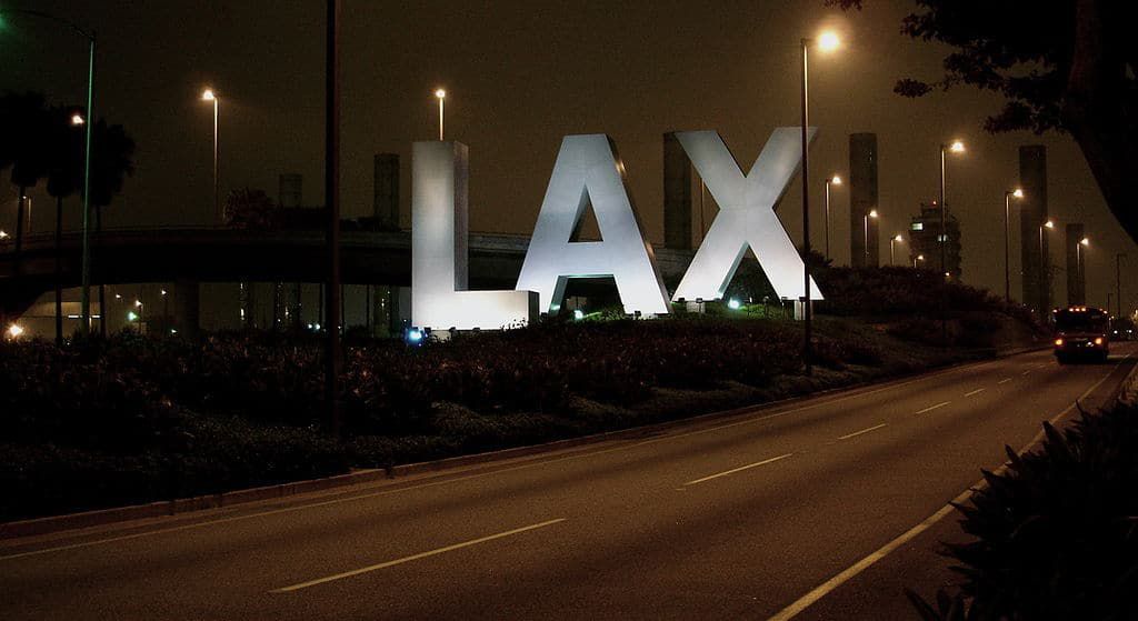 Los Angeles International Airport sign at night - The stories we're living