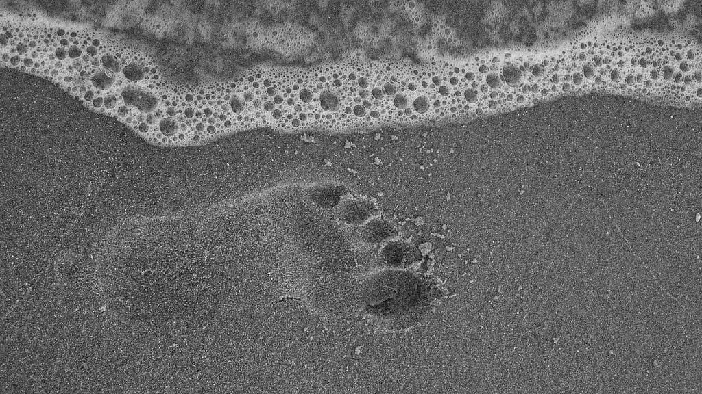 footprint on the beach close to wave