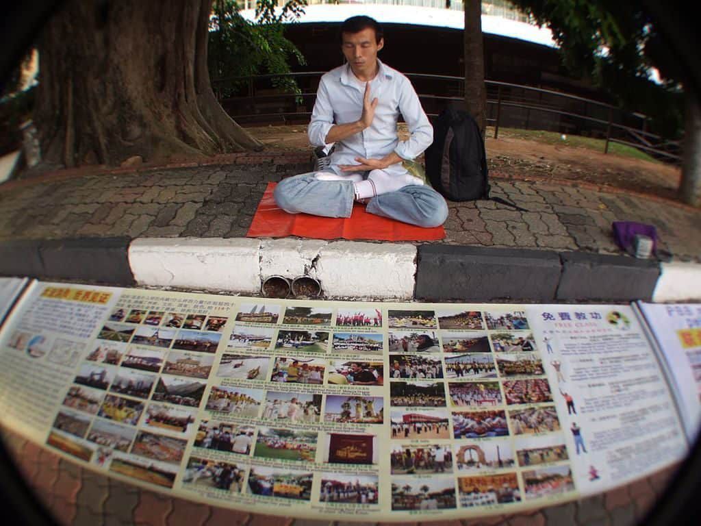 Falun Gong, Malaysia man sitting in meditation with photos