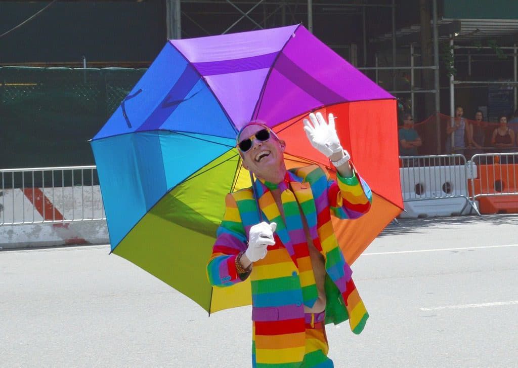 gay person with umbrella in lgbt rainbow colours