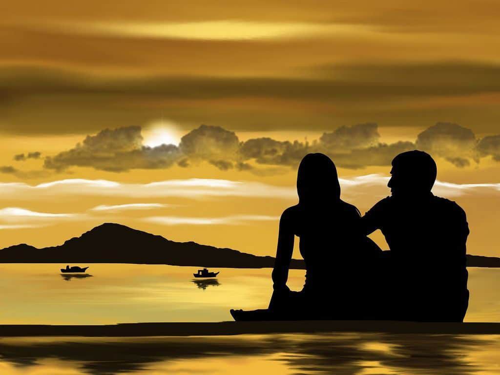 couple talking on a beach at sunset