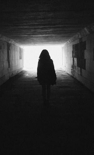 Woman walking through dark tunnel towards light - Thanking Anne Lamott