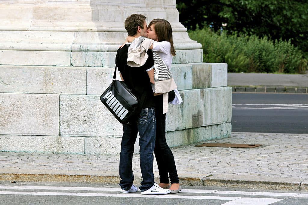 Young couple kissing on street in stylish clothes - The happiness challenge